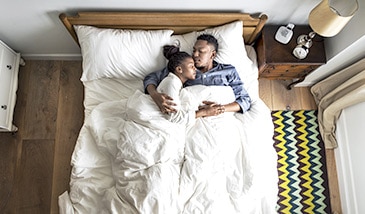 kuschelndes Paar im Bett ohne lästige Besucherritze